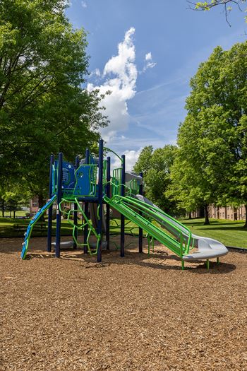 A playground with a green slide and a blue climbing frame.at Deer Park Apartments, Maryland, 21133